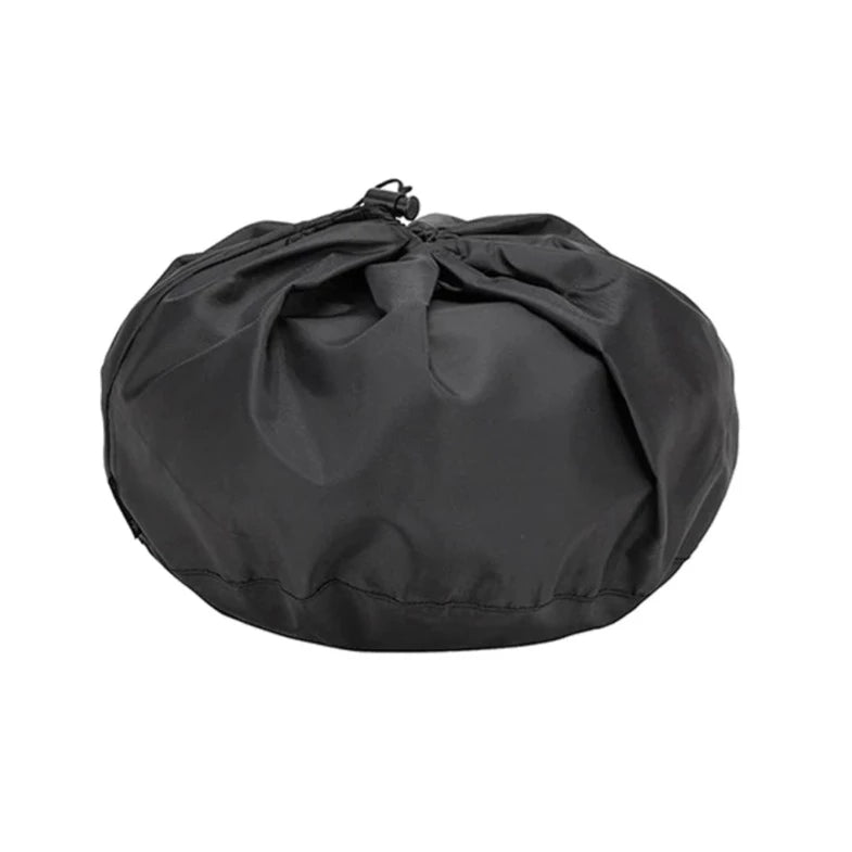 A black drawstring bag sits closed with gathered fabric at the top, forming a round, slightly flattened shape against a plain white background—an ideal way to store your Snow Peak Field Cooker Pro portable cook set for camping, perfect for keeping your non-stick cookware and other cooking essentials organized.