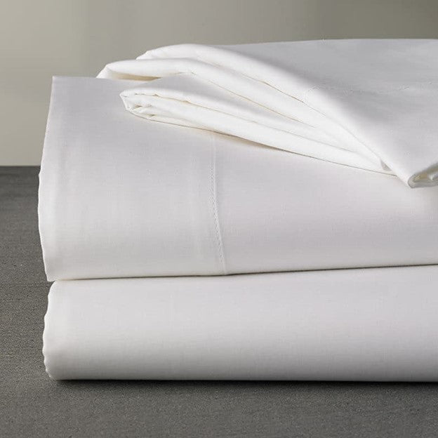 A neatly folded stack of Airstream Custom 300 Thread Count Sheets for Atlas 25MS rests on a gray surface, set against a neutral background.