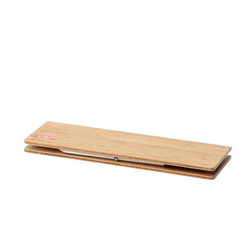 A closed rectangular wooden box with a visible hinge and a small red label on the top left corner, featuring a sleek design reminiscent of the Snow Peak Renewed Single Action Low Table.