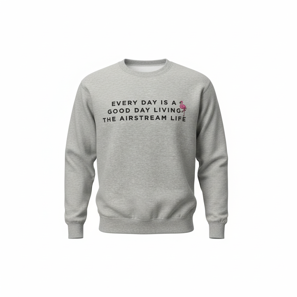 Introducing the Airstream Good Day Flock Sweatshirt: a cozy gray sweatshirt featuring the phrase “EVERY DAY IS A GOOD DAY LIVING THE AIRSTREAM LIFE” across the front, accented by a small pink flamingo graphic next to the letter “A.” This comfy piece perfectly captures vintage travel vibes paired with a whimsical flamingo touch.