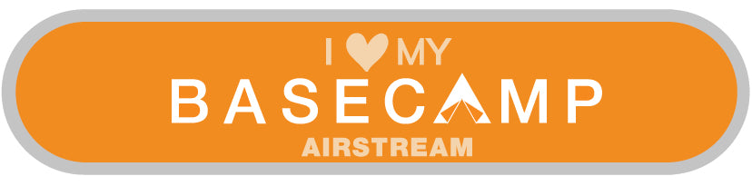 Orange oval I Love My Airstream Bumper Sticker with white text: I ♥ MY BASECAMP and AIRSTREAM underneath. The “A” in BASECAMP is designed to look like a tent. These weather-resistant stickers are perfect for adventure lovers and make great travel trailer decals for your next trip.