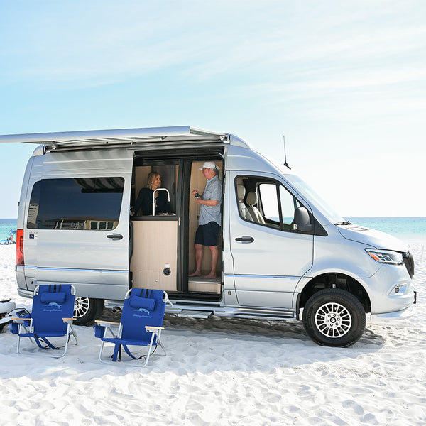 Interstate on beach sand with two blue chairs