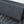 Close-up of a dark gray mesh fabric product, showing the detailed woven texture and folded structure against a light gray background.
