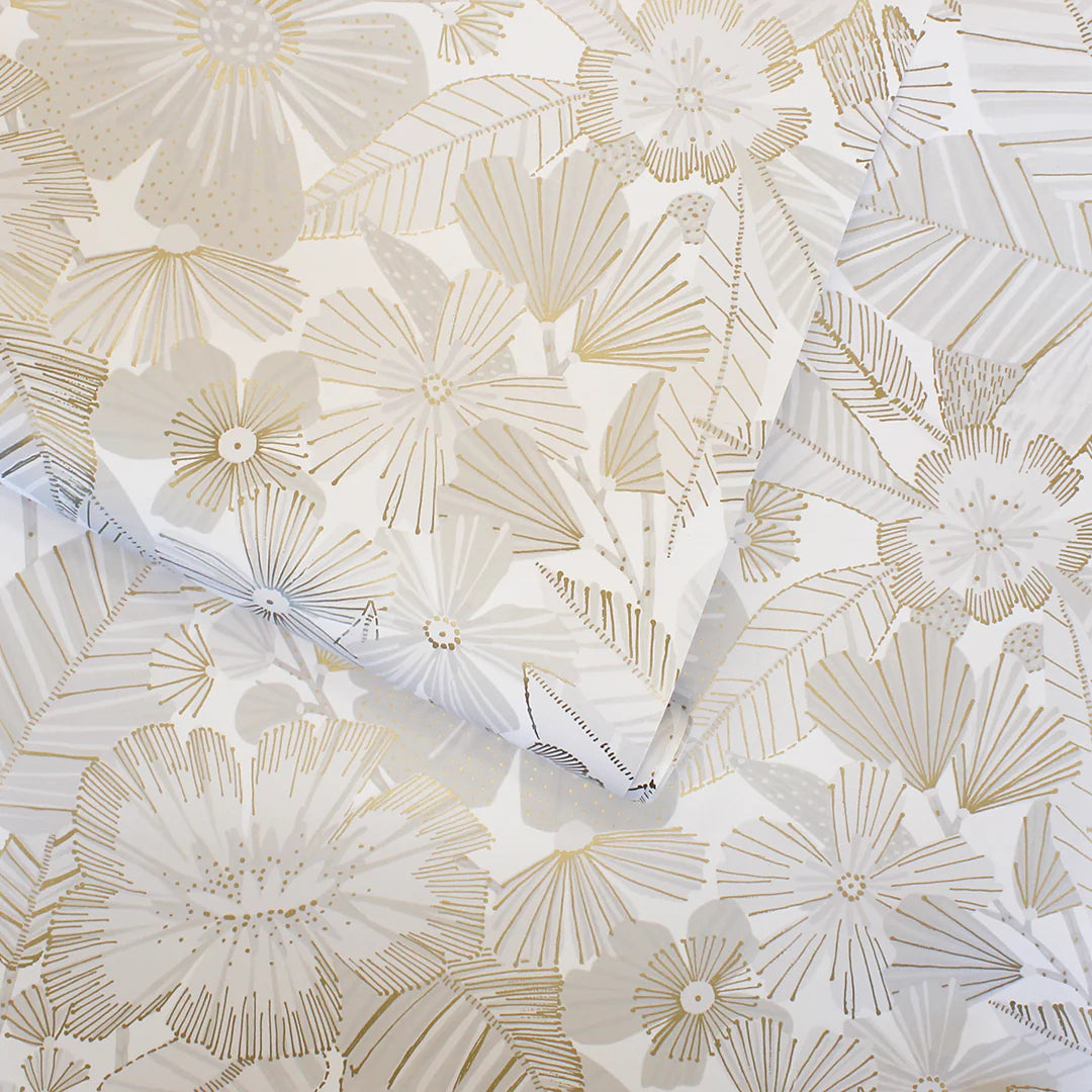 Metallic Bloom Peel + Stick Removable Wallpaper features white paper adorned with elegant gold and silver floral patterns of abstract flowers and leaves. The overlapping sheets highlight the delicate metallic design, making them an ideal, removable décor choice for chic Airstream interiors or any space seeking stylish and easy-to-apply wallpaper beauty.