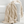 Beige chunky knit blanket draped over a white surface