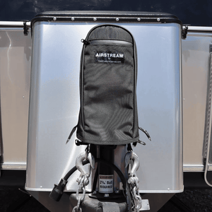 Black water-resistant Airstream Water Resistant Jack Cover protecting the trailer power jack on the front of an aluminum travel trailer.