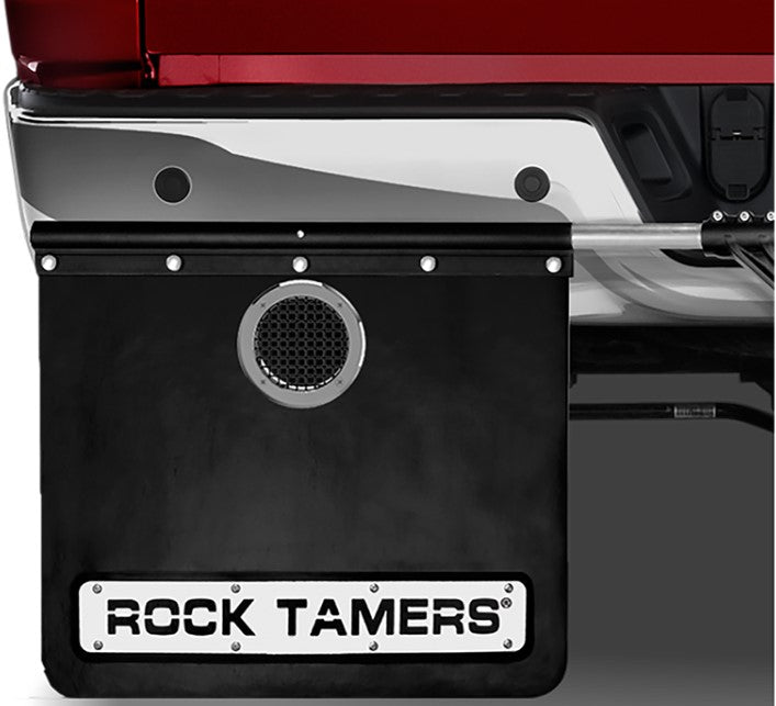 The Rock Tamers 2 Pack Exhaust Outlet features black rubber mud flaps for pickup trucks, each equipped with a circular mesh vent for exhaust flow and a rectangular plate at the bottom displaying “ROCK TAMERS” in bold black lettering. Designed specifically for vehicles with rear-facing exhaust systems, these mud flaps serve as effective exhaust flow accessories.
