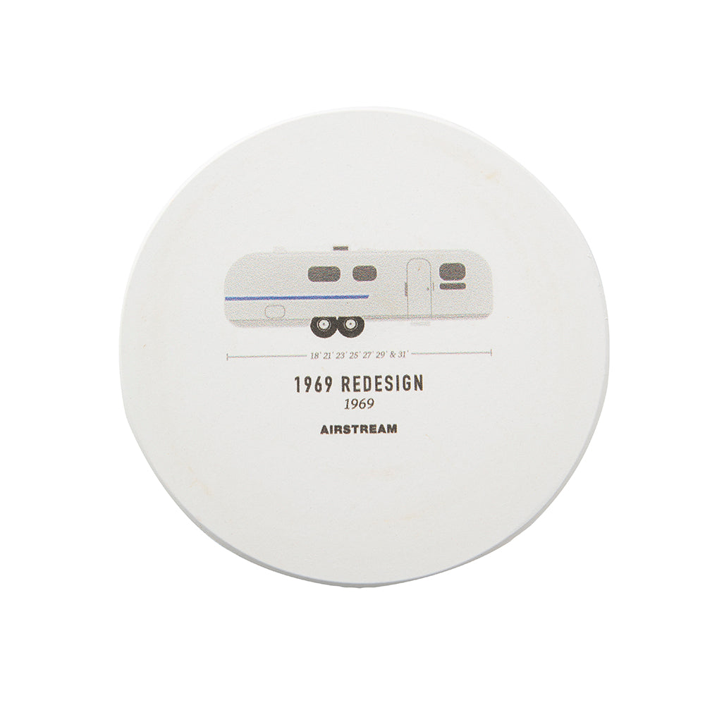 Introducing the History of Airstream Coasters: a round, white stone coaster showcasing a minimalist illustration of the 1969 Airstream trailer. Below the image, the text “1969 REDESIGN 1969 AIRSTREAM” is displayed alongside a practical size guide in inches. Ideal for enthusiasts of classic Airstream models and those seeking stylish home décor accents.