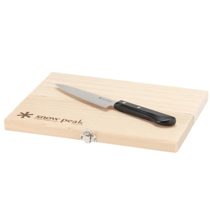 A Snow Peak Medium Chopping Board Set with a black-handled knife rests on a light birch wood board featuring a clasp and the Snow Peak logo in the corner, making it perfect for outdoor cooking adventures.