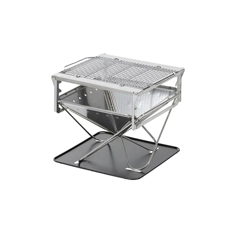 The Takibi Fire & Grill by Snow Peak is a compact, foldable stainless steel camping grill inspired by Japanese design, featuring a mesh grate top, sturdy metal frame, and an integrated drip tray underneath—ideal as a portable fire pit—shown isolated on a white background.