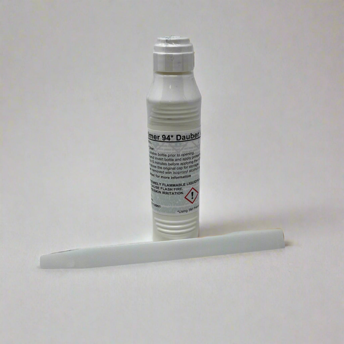 A white plastic bottle labeled “Primer 94 Dauber” stands upright with a white plastic stick lying in front of it on a plain, light background—an essential component of the Airstream Replacement Trim Tool Bundle, perfect for use as an adhesive primer during rub rail replacement or other Airstream trim tool projects.