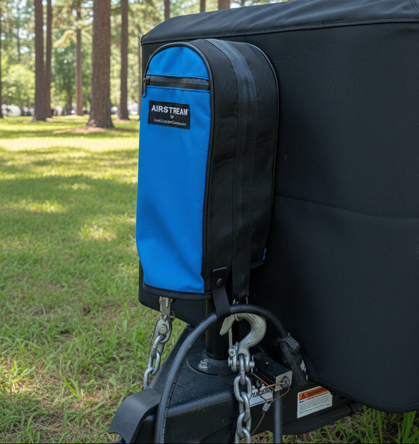 Airstream travel trailer with a blue storage bag attached to the back