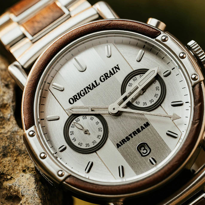 Close-up of a watch with 'Original Grain' and 'Airstream' branding on a textured surface.