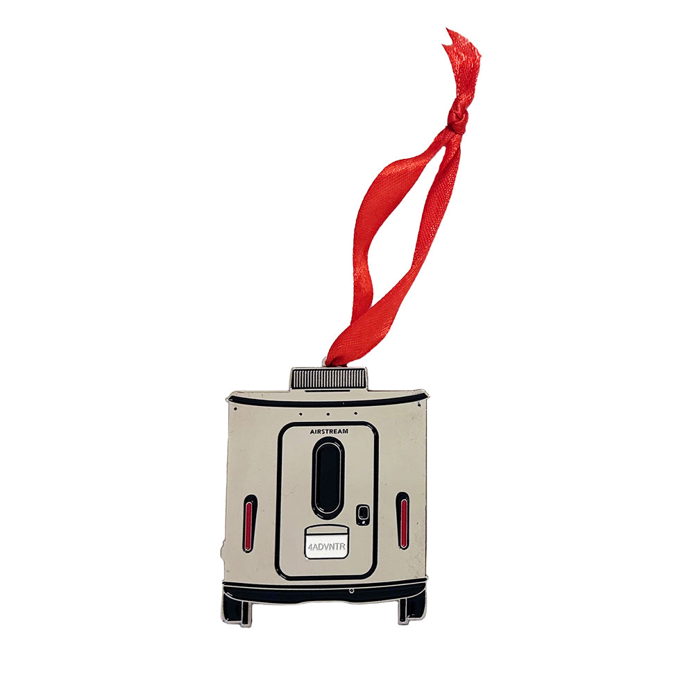 The Airstream Basecamp Trailer Flat Ornament is a metal decoration designed in the shape of an Airstream Basecamp trailer. It comes with a red ribbon for hanging, making it the perfect gift for anyone who loves adventure and dreams of hitting the road in an Airstream.