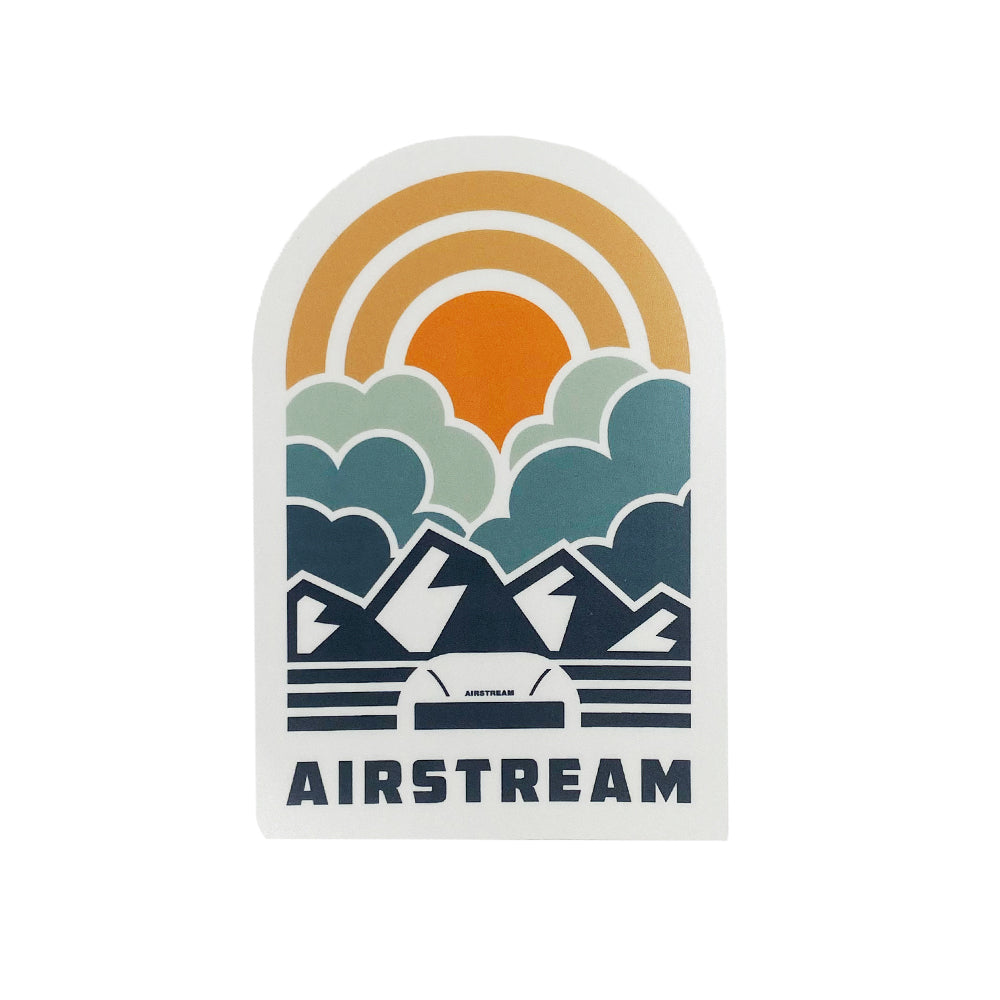 Show off your adventurous spirit with the Airstream Horizons Vinyl Removable Sticker, featuring a stylized illustration of mountains, clouds, and a setting sun above an iconic Airstream trailer. “AIRSTREAM” appears in bold at the bottom, while muted blue, orange, and green tones add subtle charm to this vinyl removable sticker.