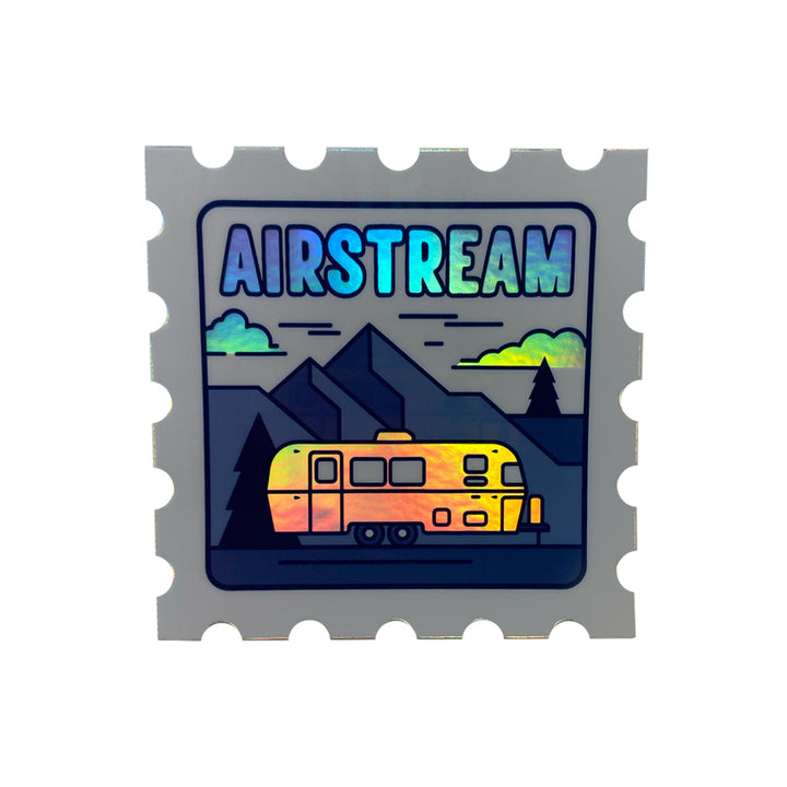 The Airstream Holographic Trailer Stamp Sticker is shaped like a postage stamp and showcases a vibrant, colorful Airstream trailer set against mountains, trees, and clouds, with “AIRSTREAM” displayed above in gradient blue-green letters. Perfect for fans of travel and adventure, this unique retro car decal makes an eye-catching addition to any vehicle or collection.