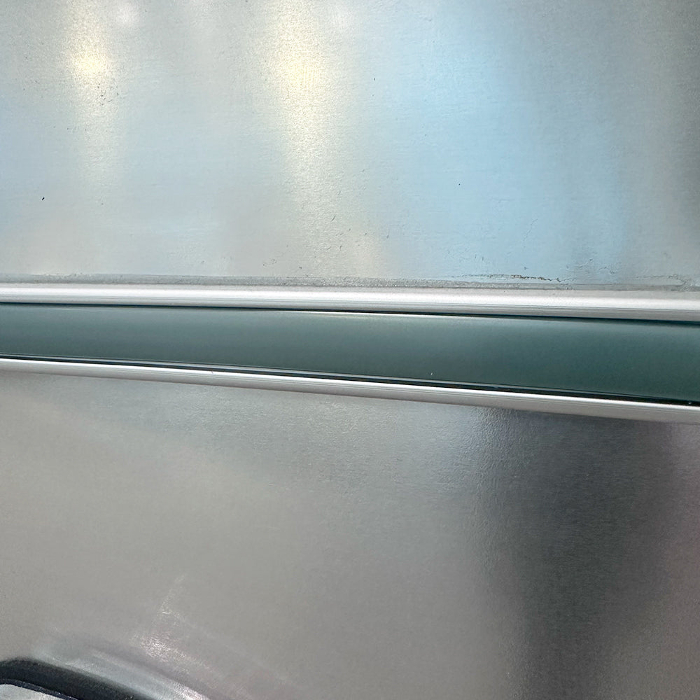 Close-up of the Airstream Premium Replacement Belt Trim for Travel Trailers, showcasing its smooth metallic silver aluminum surface with a horizontal green and white stripe. The high-quality trim features subtle texture and gentle reflections, making it an ideal exterior accessory or replacement part for your Airstream travel trailer.