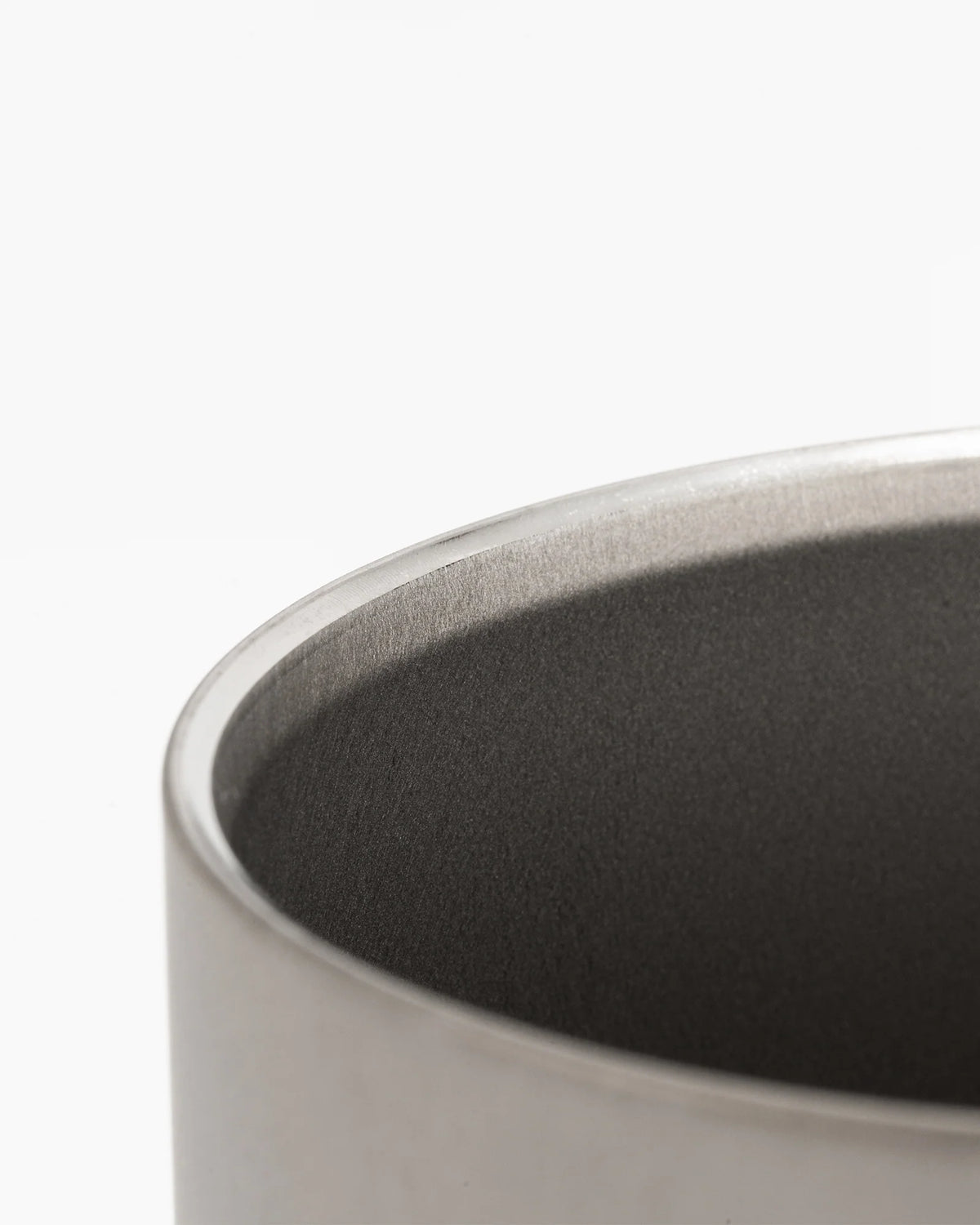 Close-up of the rim and inside of the Snow Peak Ti-Double Insulated Mug 450ml against a plain white background. This ultralight Japanese titanium mug boasts a sleek metallic finish, making it ideal for outdoor adventures.