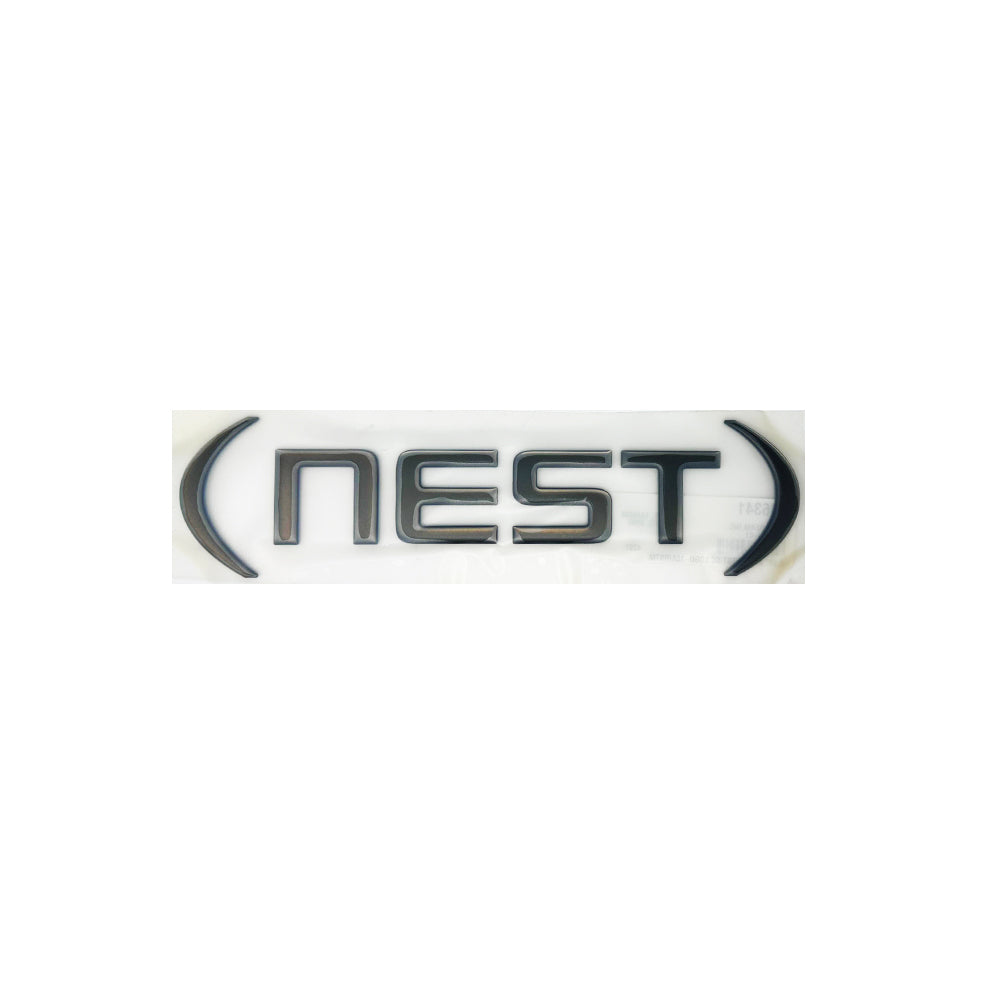 The image features the word NEST in bold, black capital letters with large curved parentheses on either side, all set against a white background—making it an ideal choice as an NLA Airstream Nest Black Chrome Logo Decal (Part # 386341) or as a replacement for your Airstream trailer emblem.
