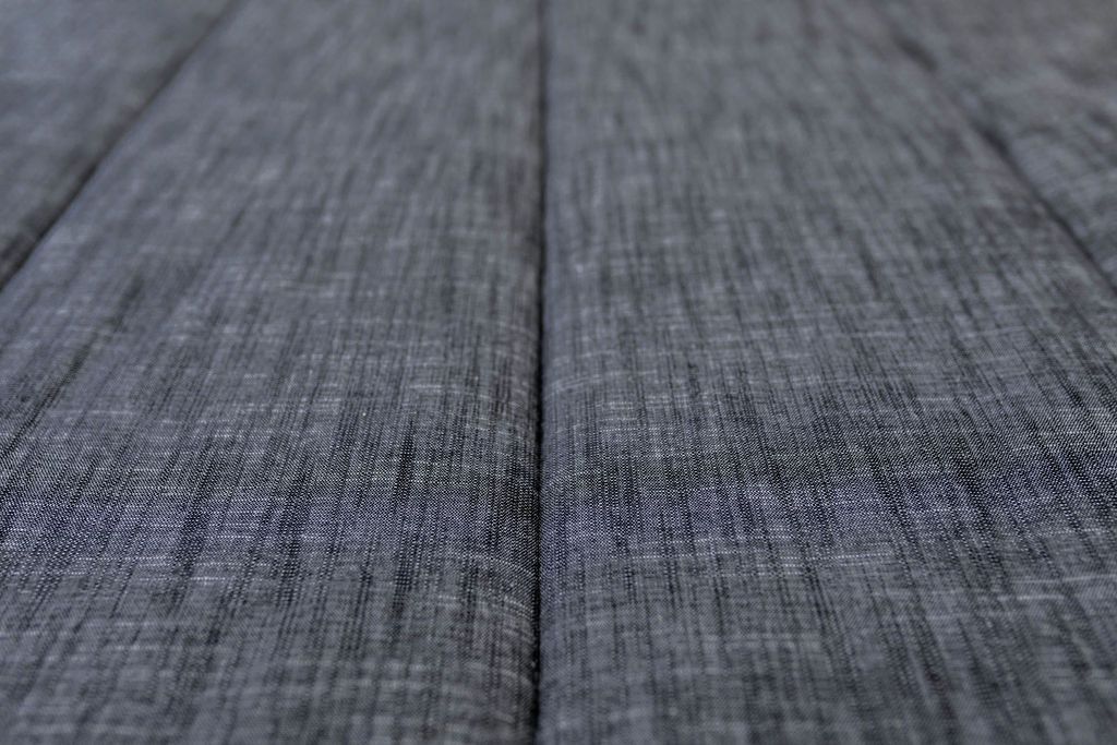 Close-up of the textured gray fabric surface of the Airstream RV Fit Beddy’s for Pan America Travel Trailers, featuring a prominent vertical seam that highlights its high-quality zippered bedding design, ideal for RV bedding setups.
