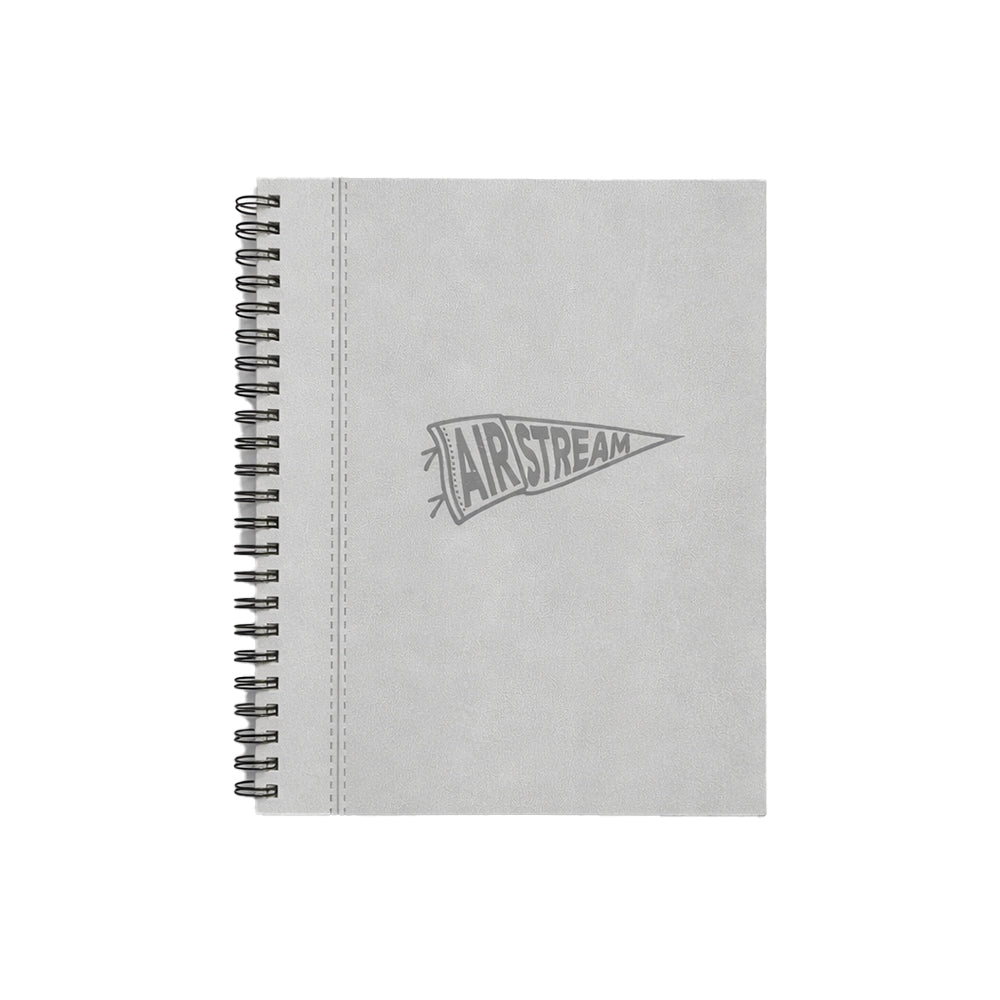 Introducing the Airstream Rally Pennant Journal—a gray spiral travel notebook featuring a stitched edge and a durable hardcover adorned with an AIRSTREAM pennant logo, perfect for documenting your adventures on the road.