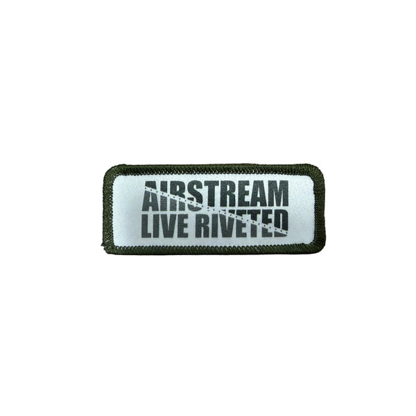A patch that can be applied with heat that has a green border and says Airstream Live Riveted