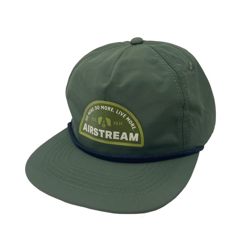 Elevate your next road trip with the Airstream See More. Do More. Live More. Rope Trucker Hat, featuring a rounded bill and a stylish dark blue cord above the brim. This hat showcases a patch with “See More. Do More. Live More.” along with “Airstream” and “EST. 1931” in green and white lettering—a perfect accessory for adventurers on the go.