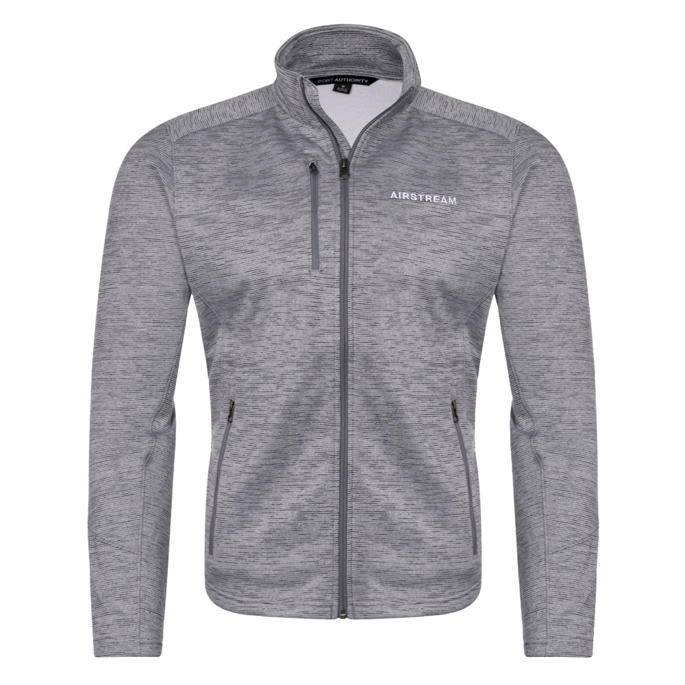 Introducing the Airstream Performance Fleece Men’s Zip Up Jacket: a gray men’s jacket crafted from midweight fleece fabric with a subtle heather pattern for added texture. This modern, fitted zip-up features black zippers on both the chest and side pockets, a high collar for extra warmth, and the iconic AIRSTREAM logo on the left chest for signature style.